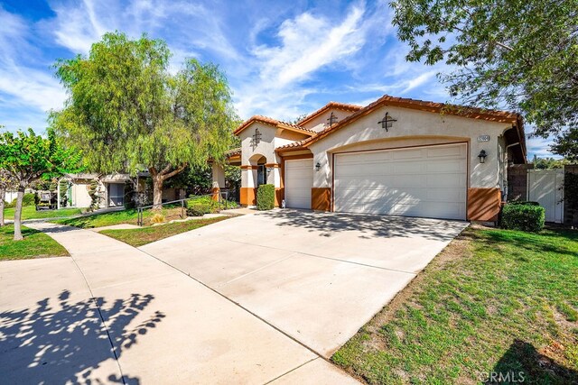 mediterranean / spanish house with a front lawn and a garage