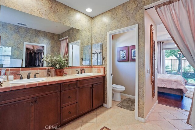 bathroom with vanity, toilet, and tile patterned floors