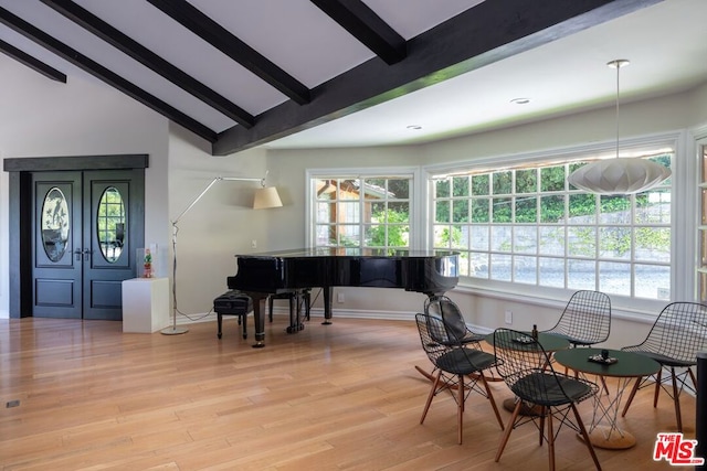 interior space with lofted ceiling with beams and light hardwood / wood-style flooring