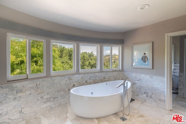 bathroom featuring a bathing tub and tile walls