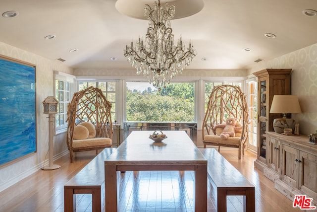 dining area with a notable chandelier, light hardwood / wood-style flooring, and plenty of natural light