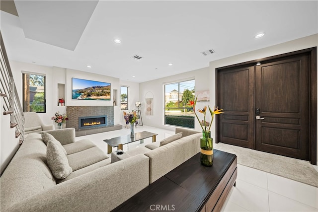 living room featuring a tile fireplace and light tile patterned flooring