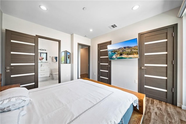 bedroom featuring wood-type flooring and connected bathroom