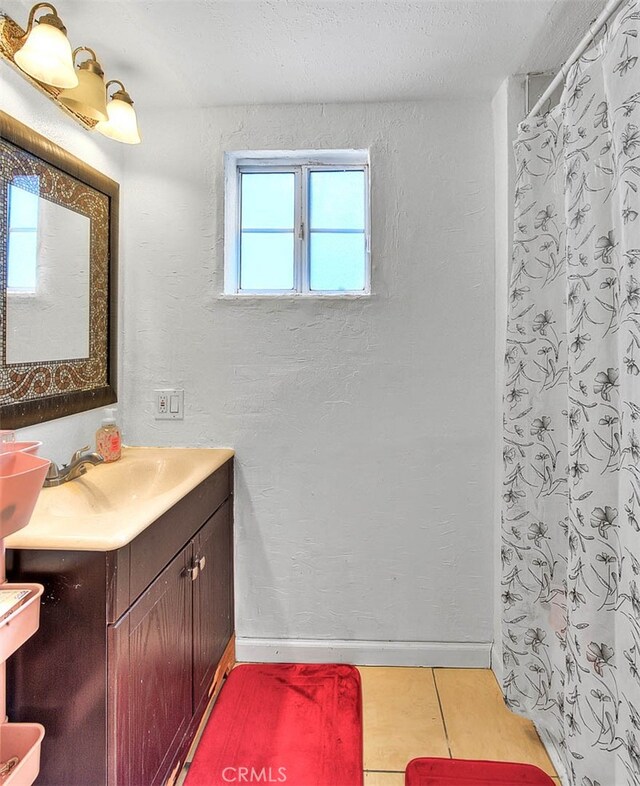 bathroom with a shower with shower curtain, vanity, and tile patterned floors