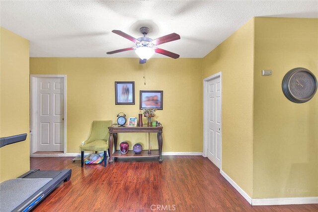 interior space with a textured ceiling, dark hardwood / wood-style floors, and ceiling fan