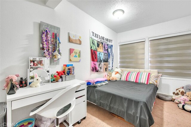 bedroom featuring light colored carpet and a textured ceiling