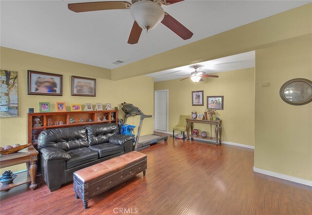 living room featuring wood-type flooring and ceiling fan