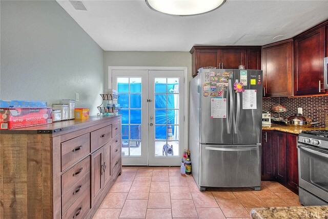 kitchen with light tile patterned flooring, tasteful backsplash, stainless steel appliances, stone countertops, and french doors