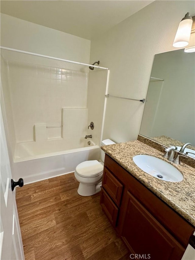 bathroom featuring shower / bathtub combination, vanity, wood finished floors, and toilet