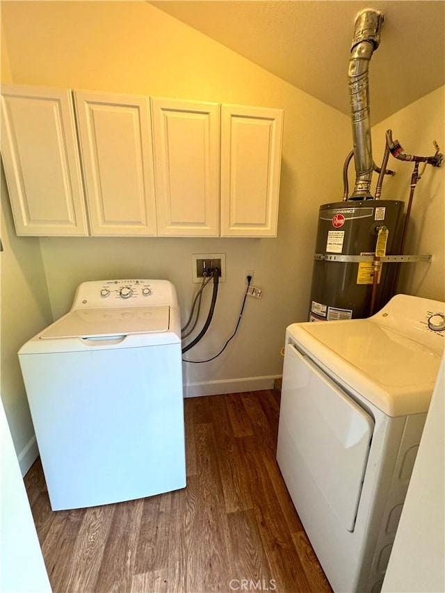 clothes washing area featuring strapped water heater, dark wood finished floors, cabinet space, washer and dryer, and baseboards