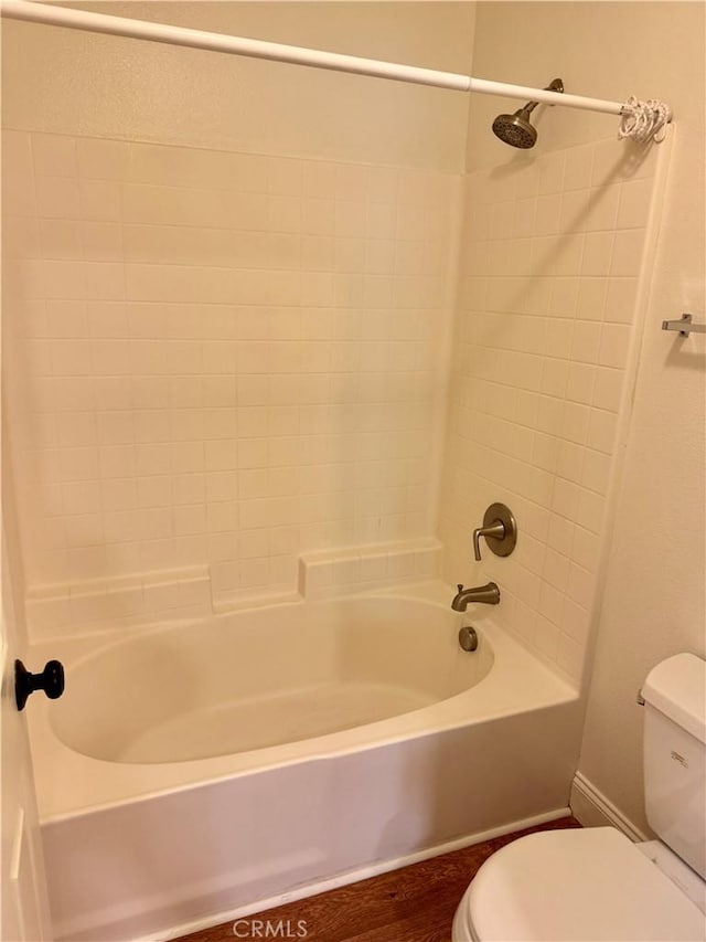 bathroom with bathtub / shower combination, toilet, and hardwood / wood-style floors