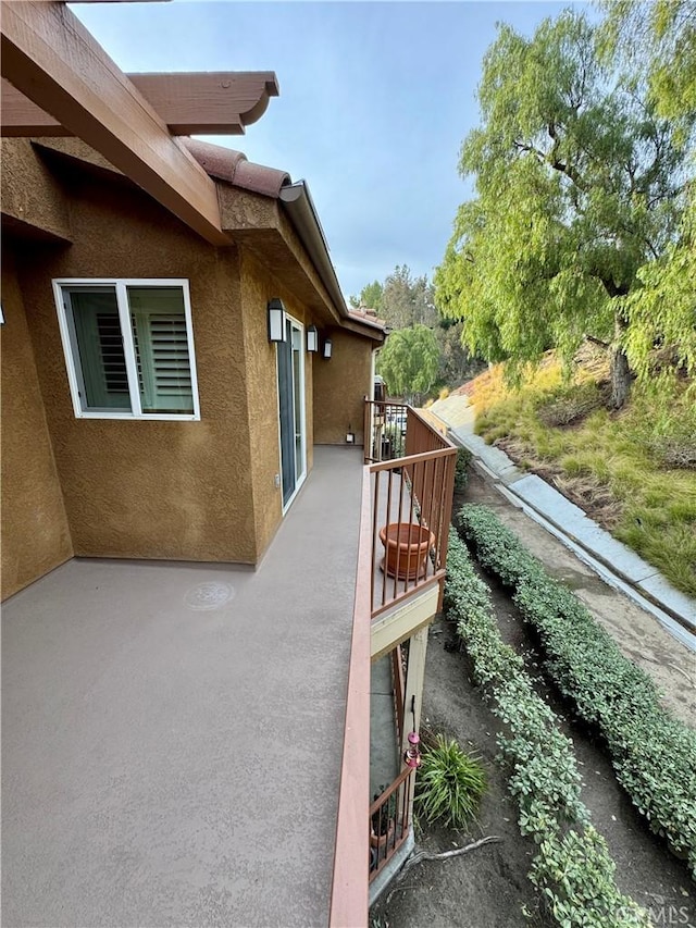 view of home's exterior with a balcony and stucco siding