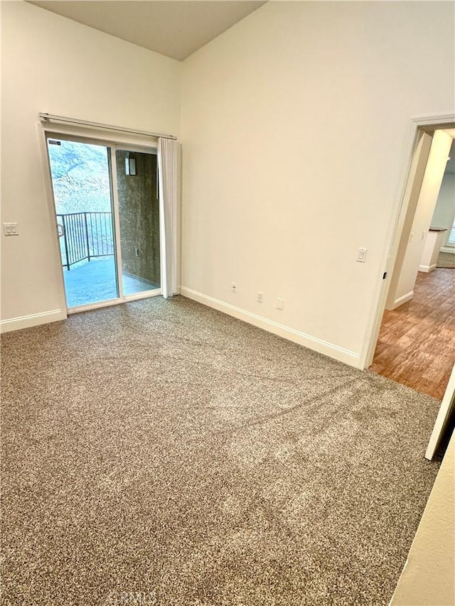 unfurnished room with carpet flooring and baseboards