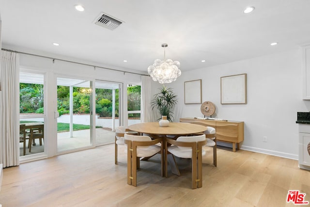 dining area with a notable chandelier and light wood-type flooring