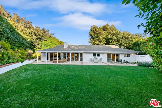 rear view of house with a yard and a patio