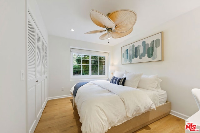 bedroom featuring a closet, light hardwood / wood-style flooring, and ceiling fan