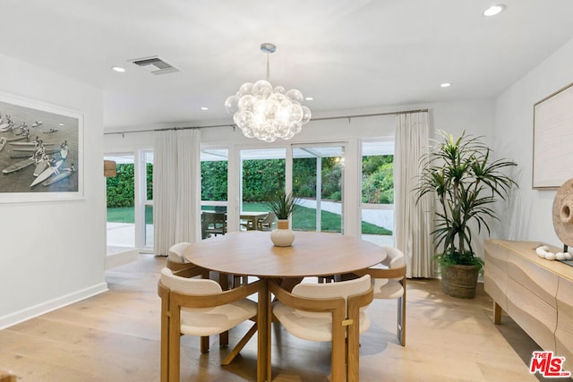 dining area featuring a notable chandelier and light wood-type flooring