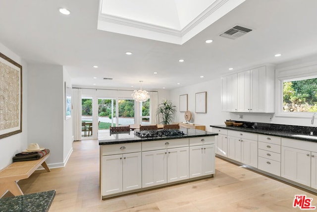 kitchen with gas cooktop, light hardwood / wood-style floors, white cabinets, and sink