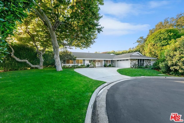 ranch-style house featuring a front yard and a garage