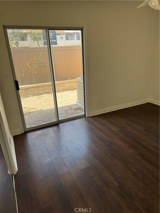 unfurnished room featuring plenty of natural light and dark wood-type flooring