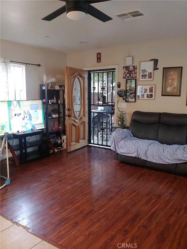 living room featuring plenty of natural light, ceiling fan, and wood-type flooring