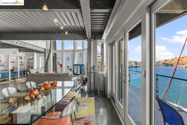 sunroom / solarium with french doors and a water view