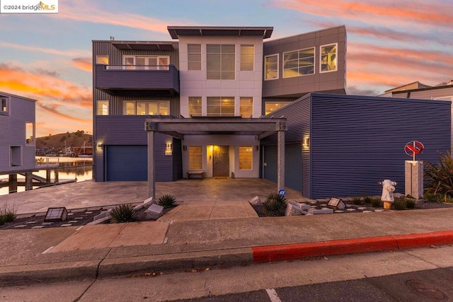 view of front of home with a garage and a water view