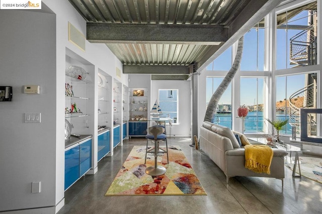 interior space featuring built in shelves, beamed ceiling, and a water view