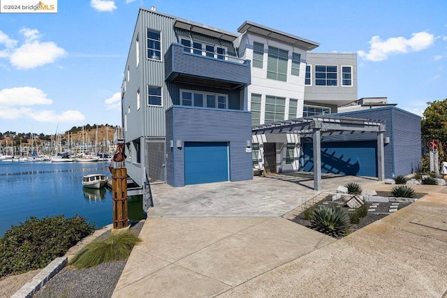 view of front of house with a garage, a pergola, and a water view