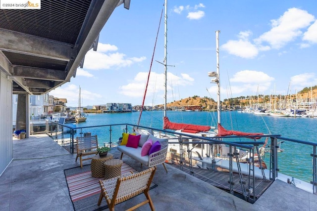 view of patio with a dock, a water view, and outdoor lounge area