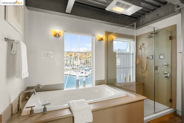 bathroom featuring tile patterned flooring, a water view, and independent shower and bath