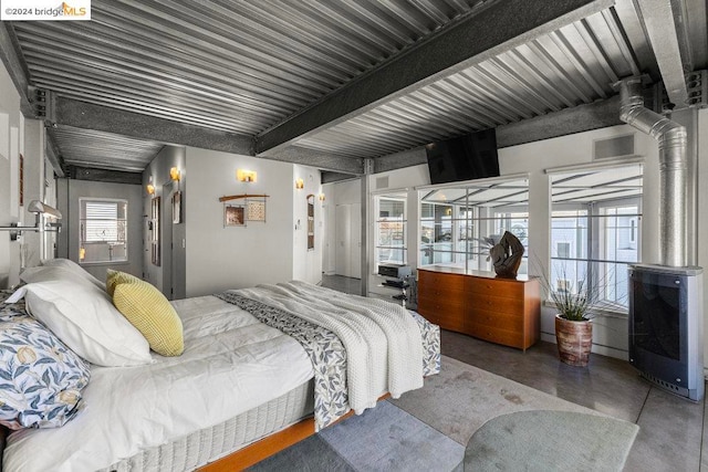 bedroom featuring concrete flooring and beamed ceiling