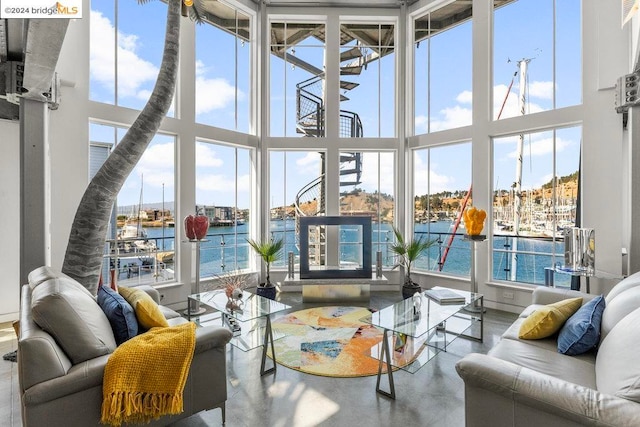 sunroom featuring a water view