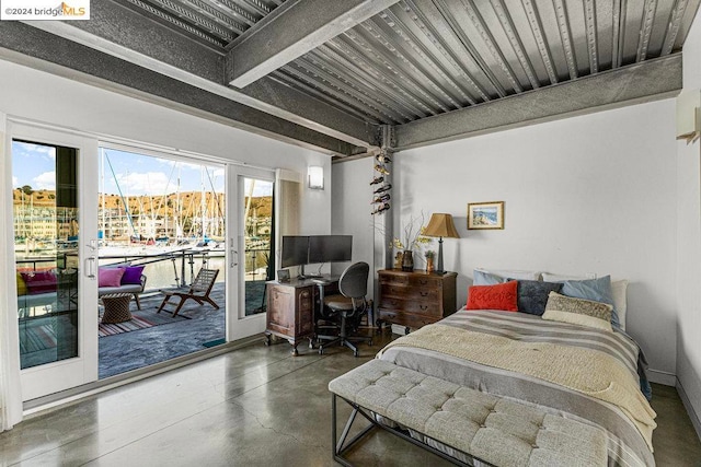 bedroom featuring beam ceiling, concrete flooring, and access to outside