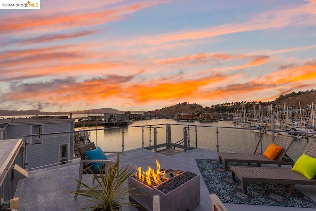 dock area with a water view and a fire pit