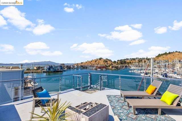 view of patio / terrace with a water and mountain view and a balcony