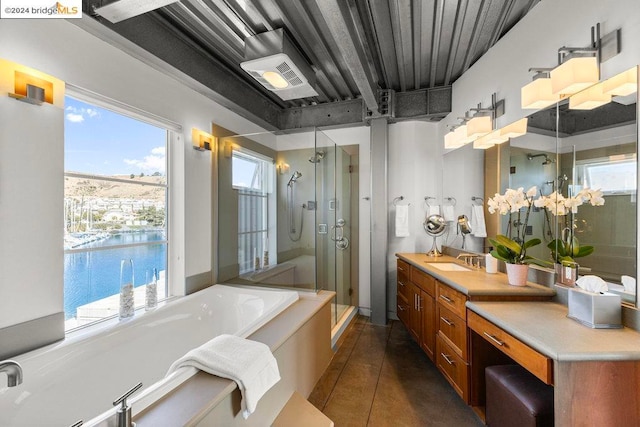 bathroom with tile patterned floors, a water view, vanity, and separate shower and tub