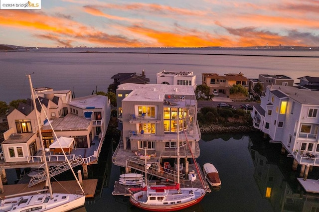 aerial view at dusk featuring a water view