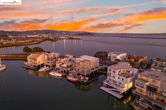 aerial view at dusk featuring a water view