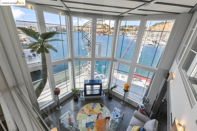 sunroom featuring a water view