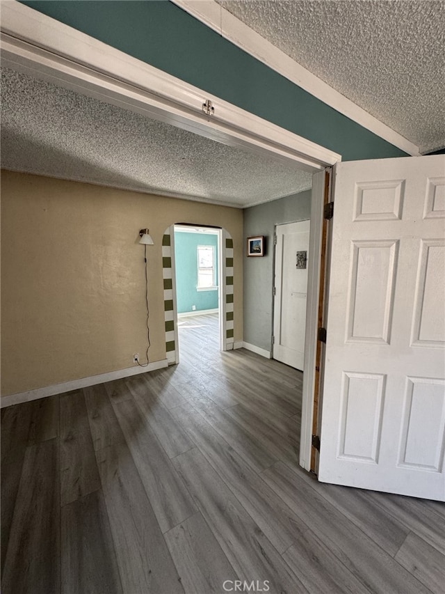 hallway with a textured ceiling and hardwood / wood-style flooring