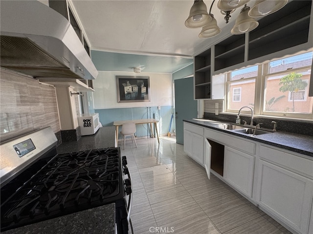 kitchen featuring light tile patterned floors, sink, stainless steel gas range, and white cabinetry