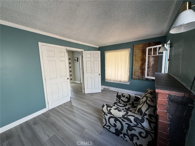 unfurnished room with crown molding, a textured ceiling, and hardwood / wood-style flooring