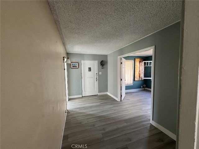 hallway with wood-type flooring and a textured ceiling