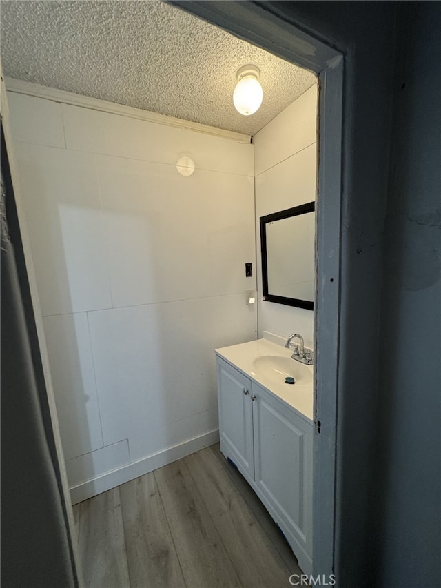 bathroom featuring a textured ceiling, hardwood / wood-style flooring, and vanity