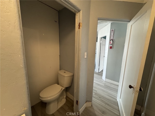 bathroom with toilet and hardwood / wood-style flooring