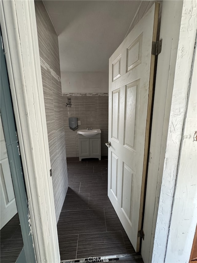 bathroom with tile patterned flooring, tile walls, and vanity