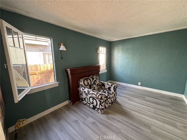 bedroom with multiple windows, a textured ceiling, and light hardwood / wood-style flooring