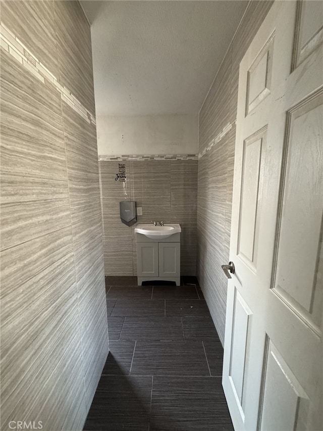 bathroom featuring tile patterned flooring, tile walls, and vanity