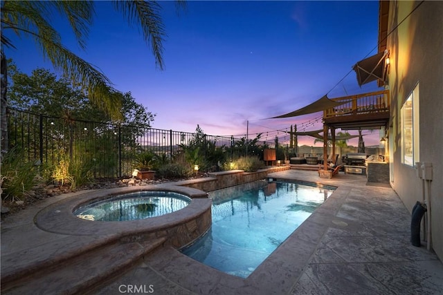 pool at dusk with an outdoor hangout area and an in ground hot tub